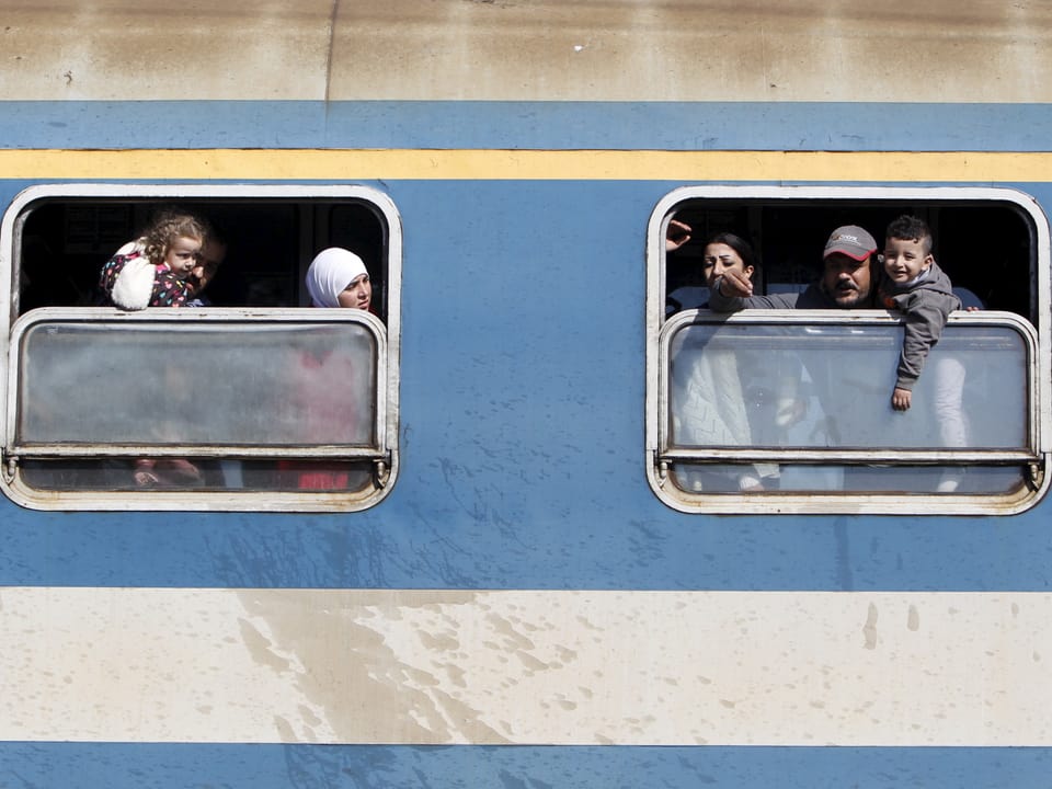 Menschen schauen aus einem Zugfenster