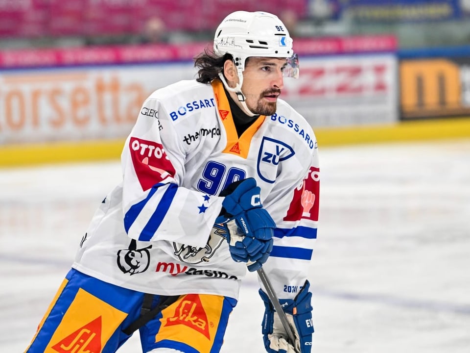 Eishockeyspieler in weisser Uniform auf dem Eis.