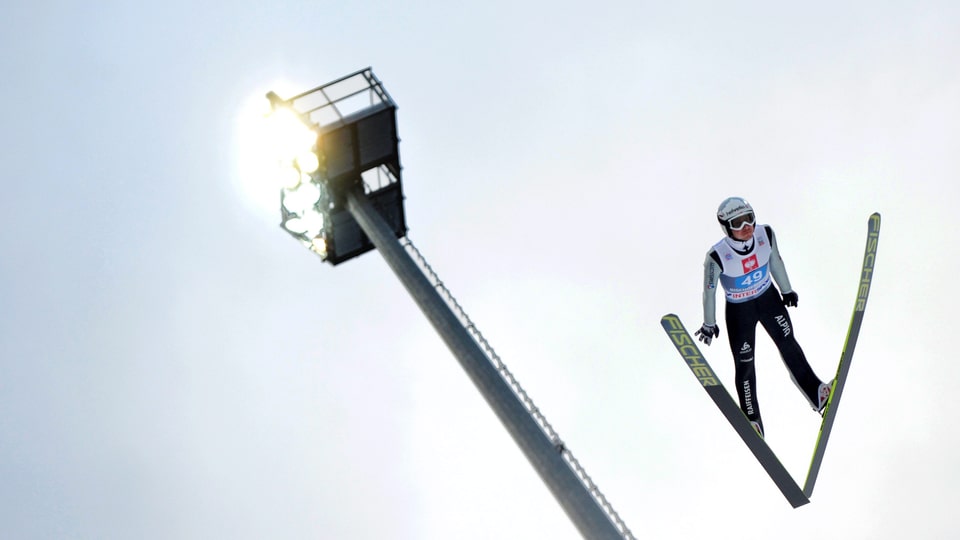 Simon Ammann in der Luft bei einem Schanzensprung.