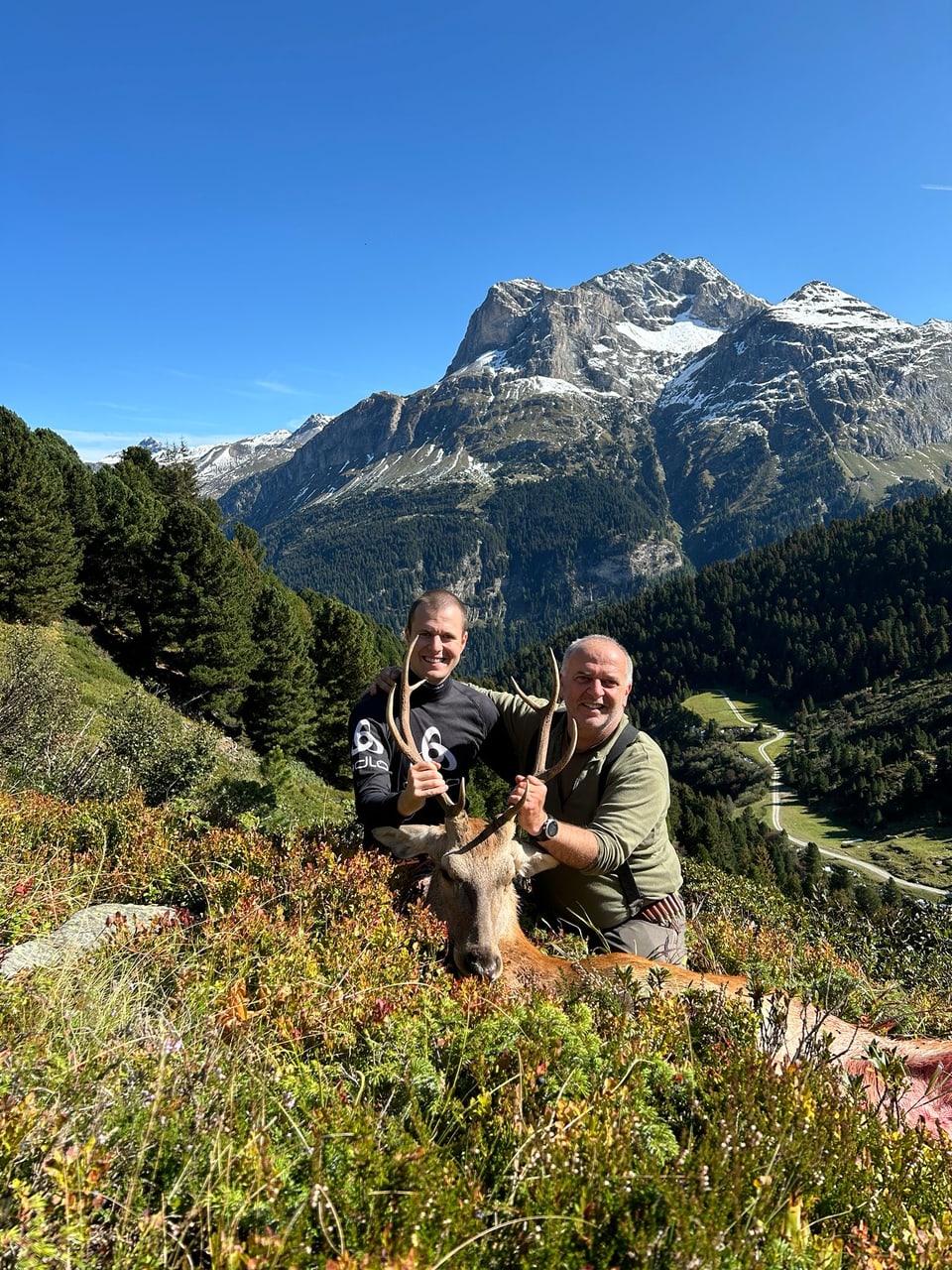 Zwei Jäger mit einem Hirschstier.