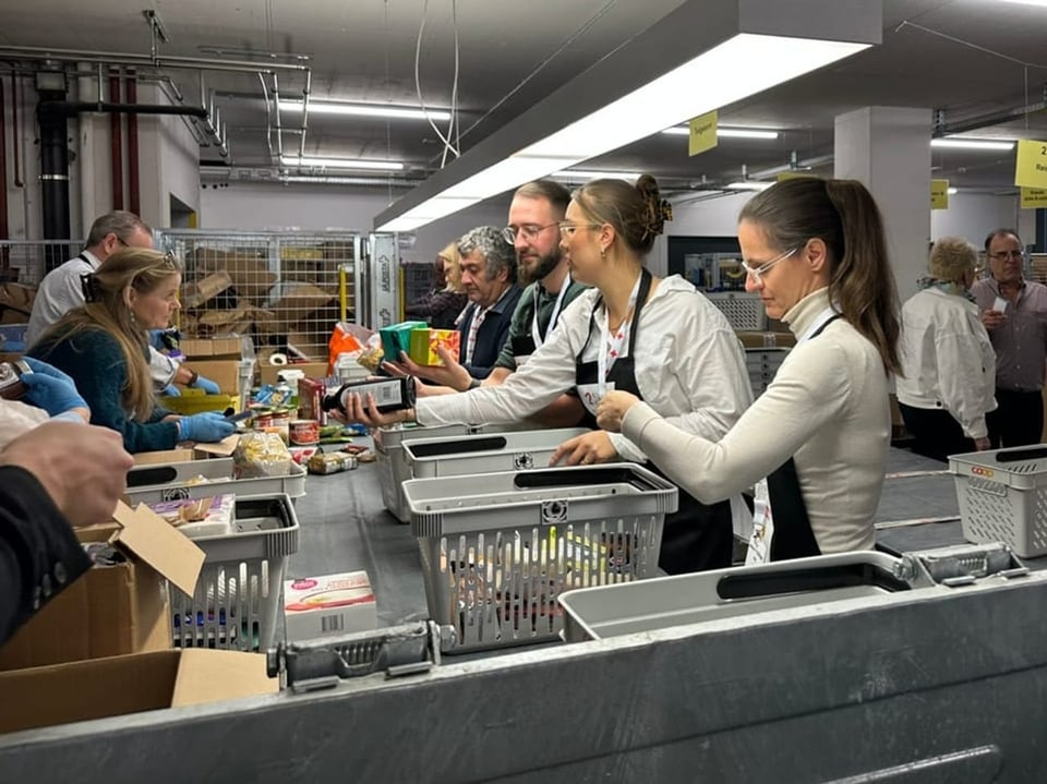 Rund 20 Freiwillige packen Pakete aus und sortieren den Inhalt