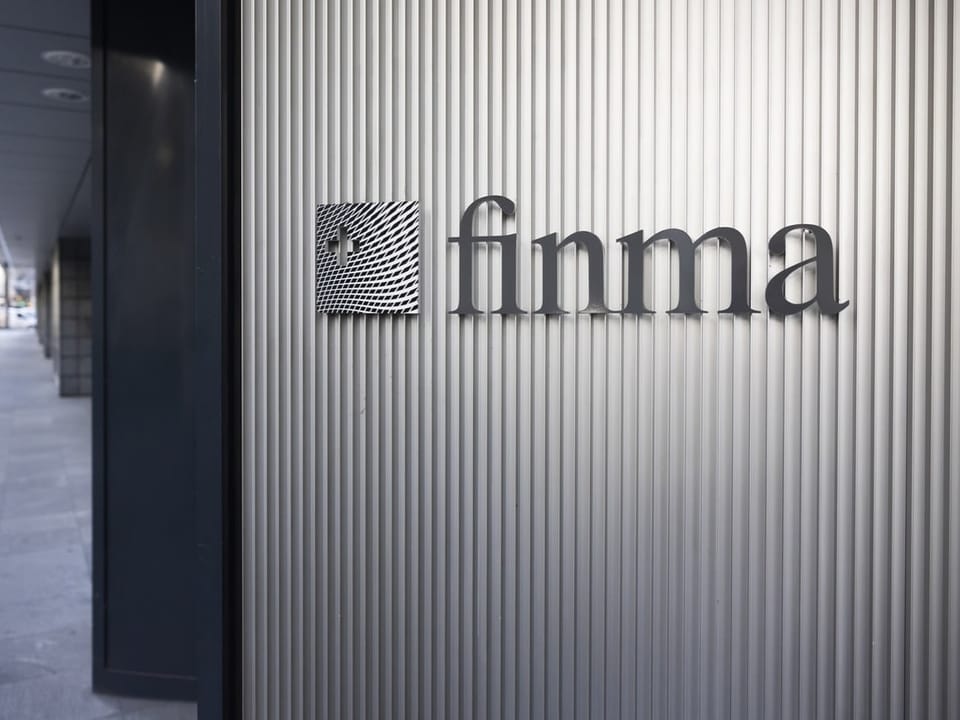 Logo der FINMA an einer geriffelten Metallwand.