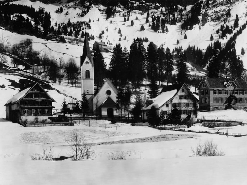 Winterliche Berglandschaft mit Dorf und Kirche.