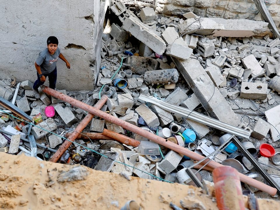 Junge in Trümmern eines eingestürzten Gebäudes.