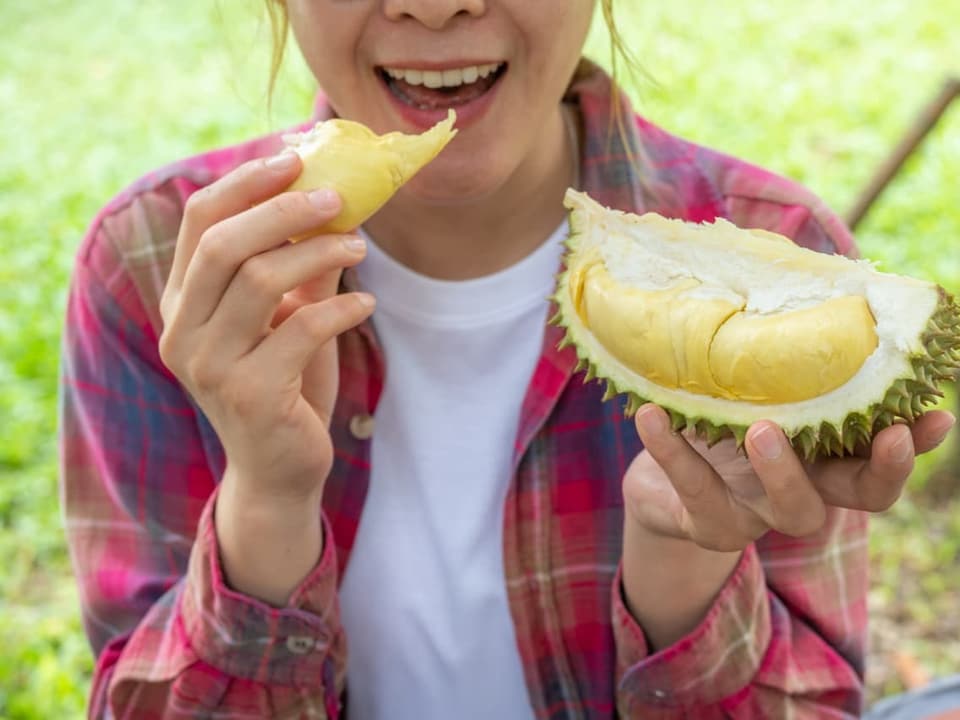 Frau isst Durian-Frucht