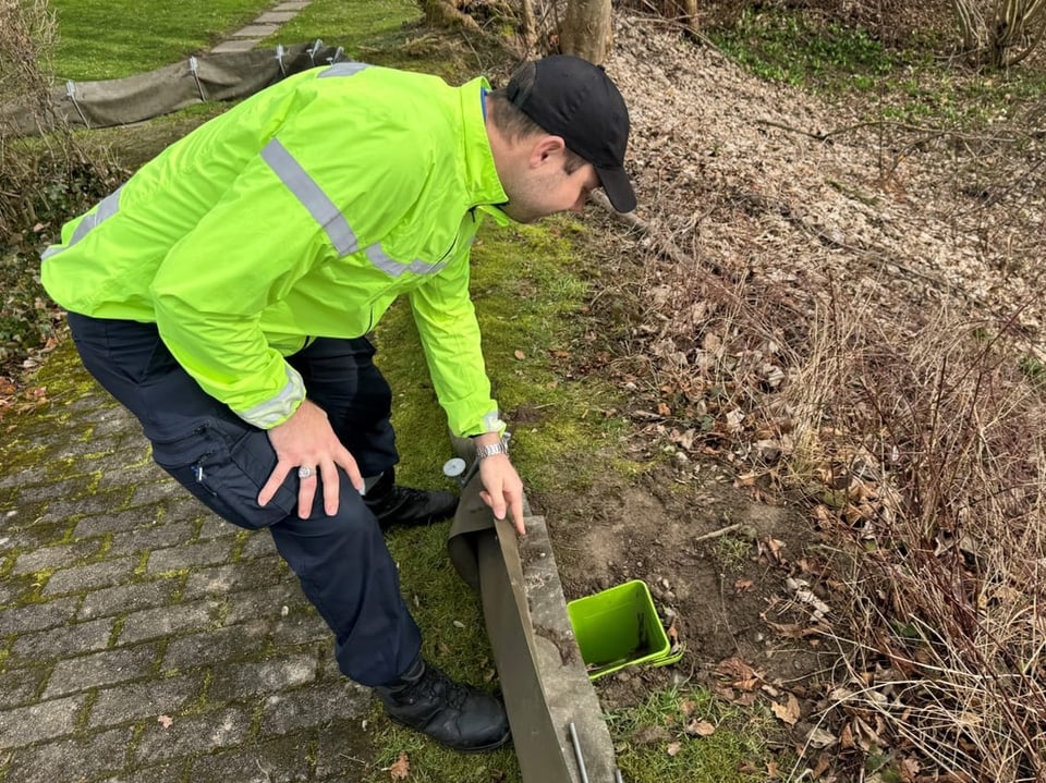 Christoph Noger beut sich über ein Amphibien-Auffangbecken.