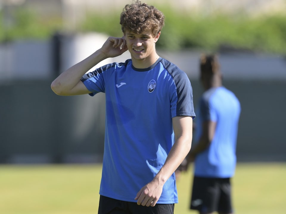 Mann in blauem Trainingshemd auf einem Sportplatz.