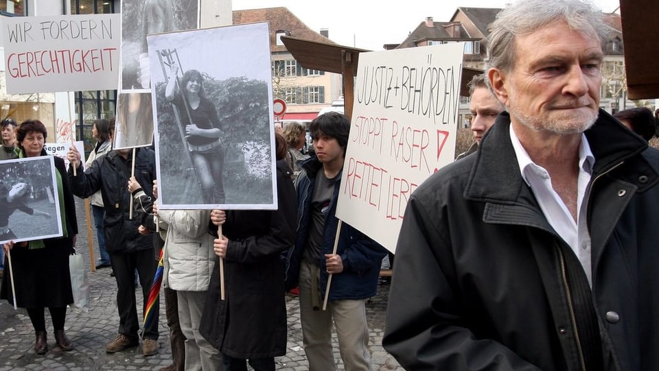 Wiederkehr und einige weitere personen mit Plakaten und Fotos der Unfallopfer.