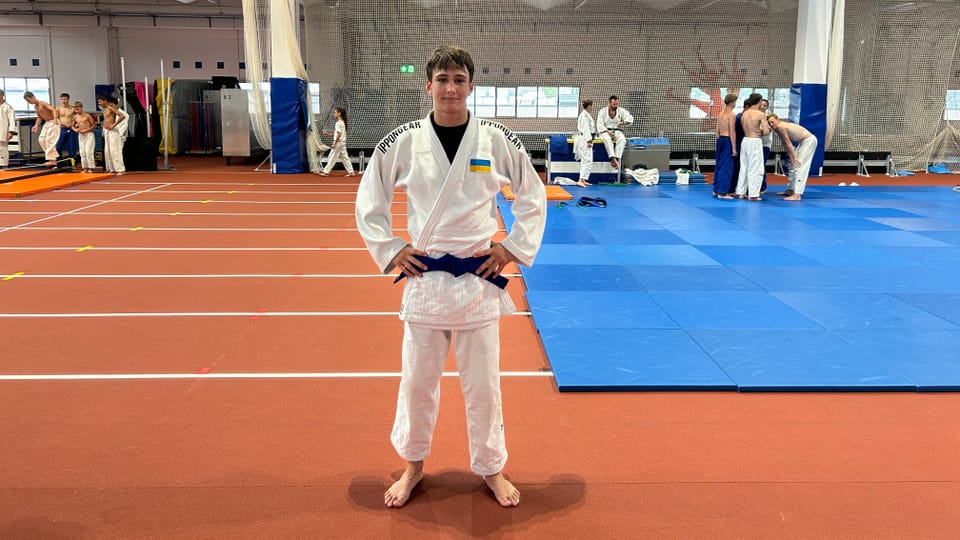 Judoka mit blauem Gürtel in Sporthalle.