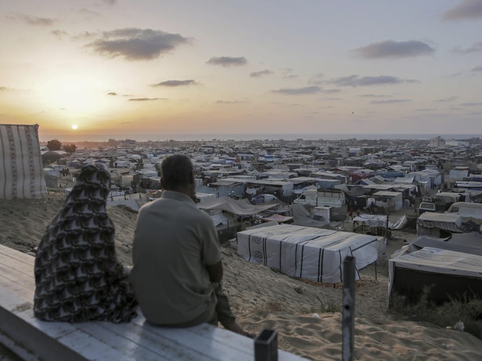 Vertriebene Palästinenser sitzen am Dienstag vor ihrem provisorischen Zeltlager in Khan Yunis.