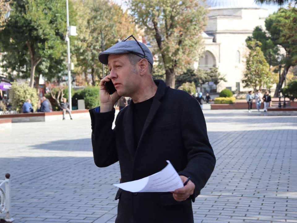 Christian von Burg am Mobiltelefon vor einer Moschee.