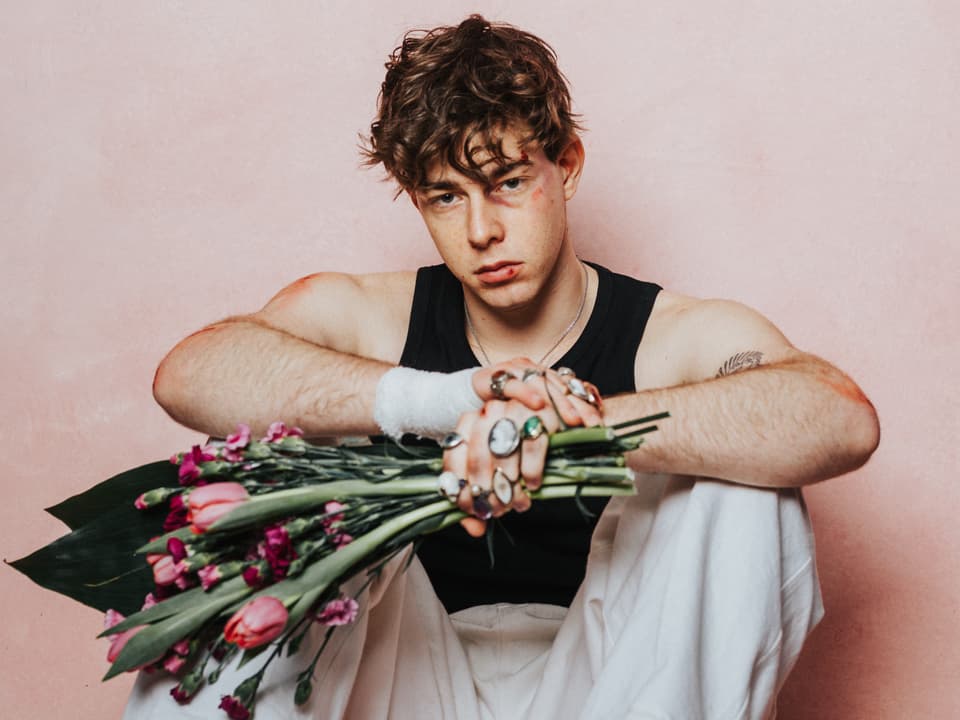 Der Musiker Mik Ivy mit einem Blumenstrauss in der Hand.