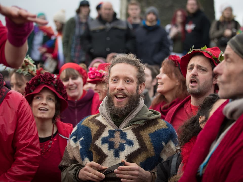 Eine Gruppe von Leuten in roten Kleidern singt