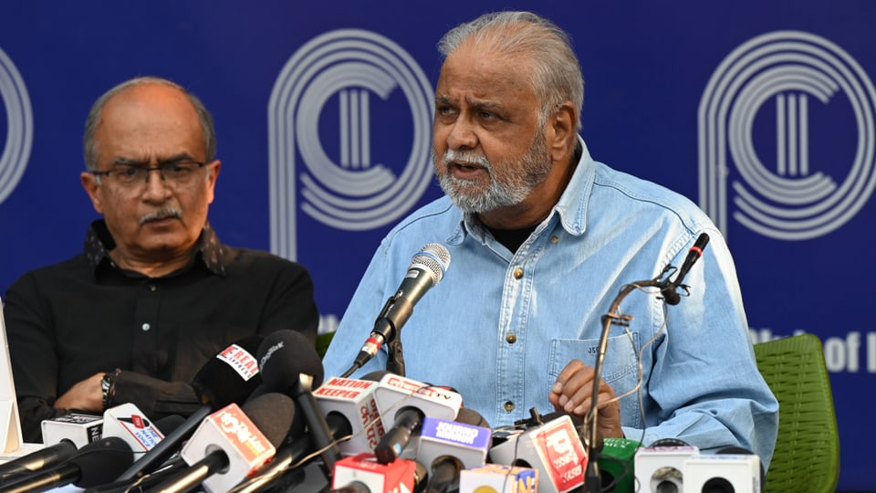 Zwei Männer halten eine Pressekonferenz vor Mikrofonen.
