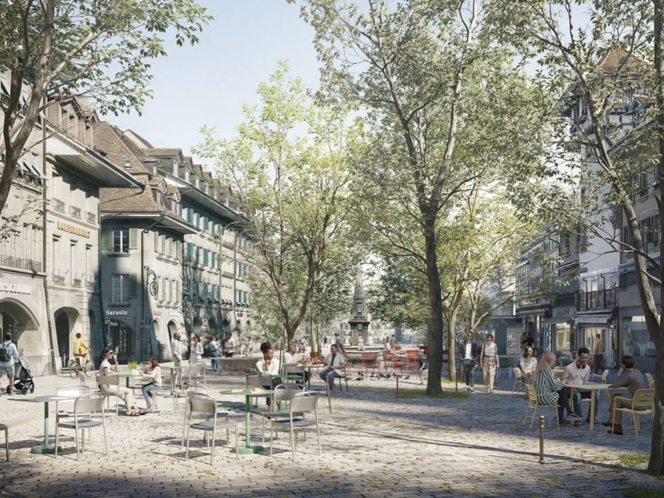 Menschen sitzen in einem Baum gesäumten Stadtplatz mit Cafés.