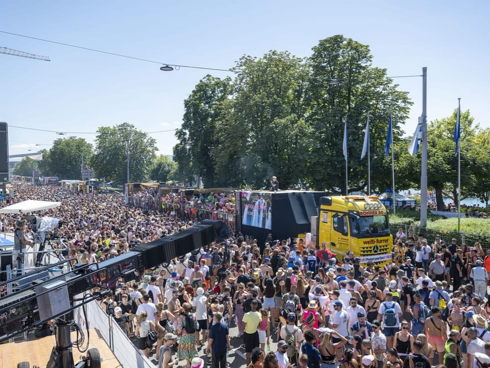 Grosse Menge bei Festival im Freien bei sonnigem Wetter, Lkw in der Menge.