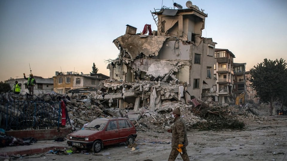 Ein Soldat läuft vor einem eingestürzten Gebäuden.