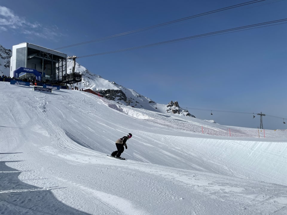 Ein Snowboarder startet zu einem Run in einer Halfpipe.