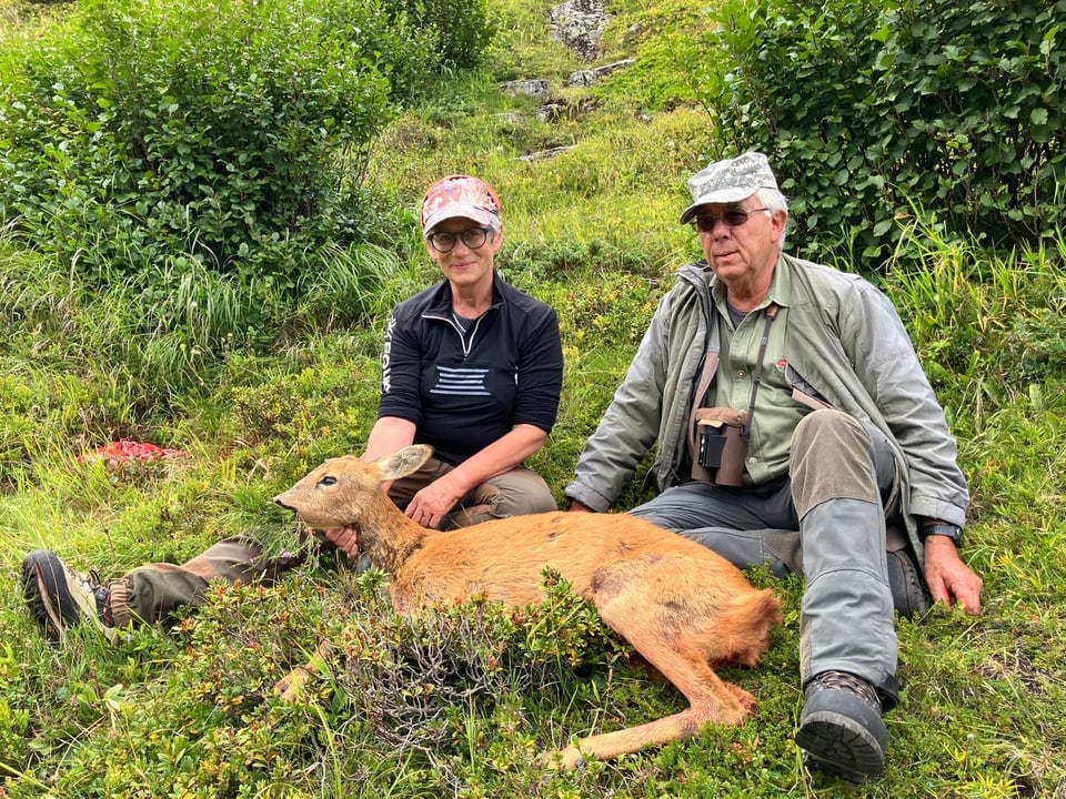 Grossmutter und Grossvater mit einer erlegten Rehgeiss, in der Region Sampuoir im Unterengadin.