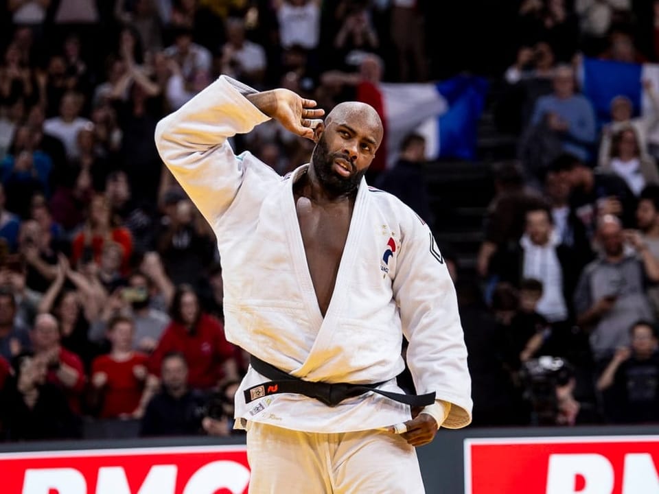 Judo-Kämpfer jubelt vor Publikum in Arena.