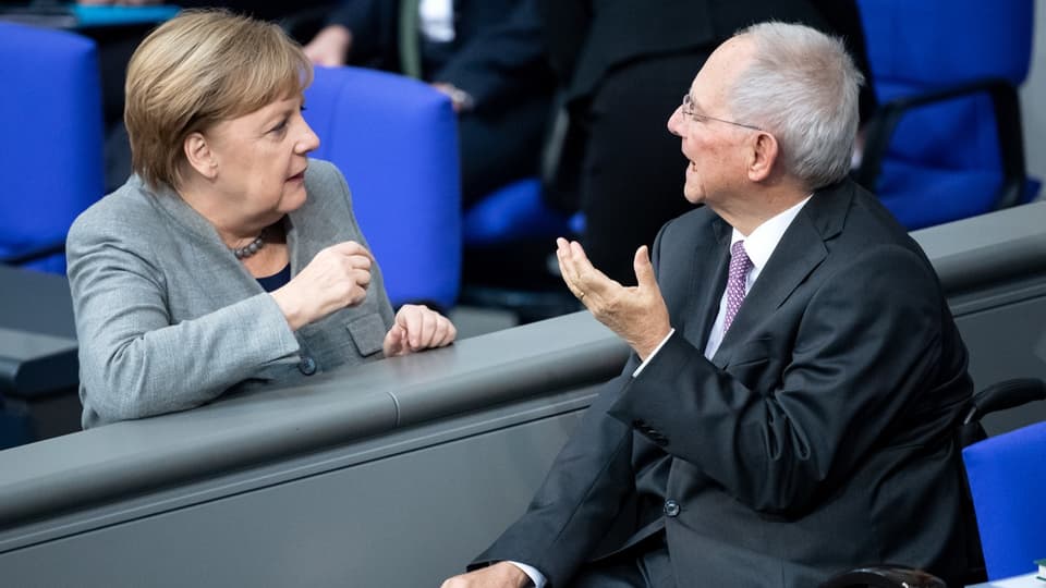 Merkel und Schäuble sprechen zusammen im Deutschen Bundestag.