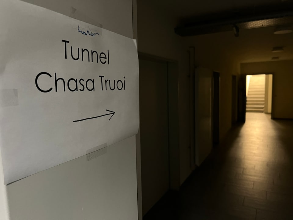 Schild 'Tunnel Chasa Truoi' in einem dunklen Flur mit einer Treppe im Hintergrund.