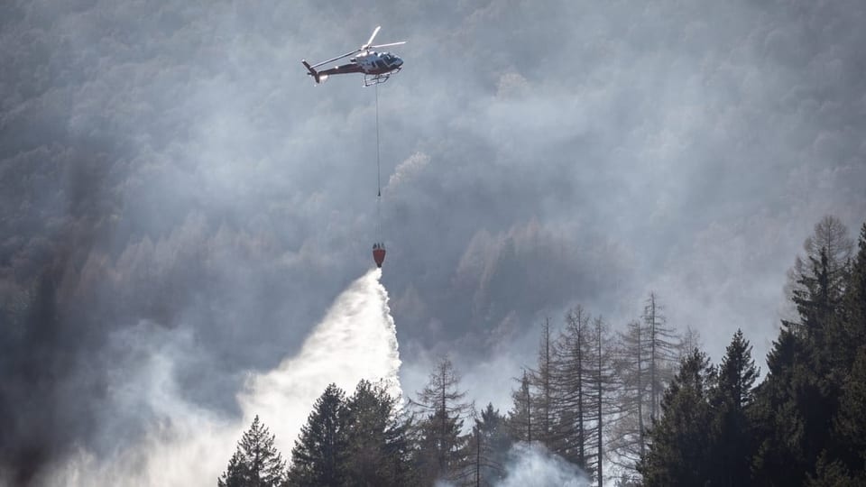 Ein Löschhelikopter versucht den Waldbrand zu löschen.