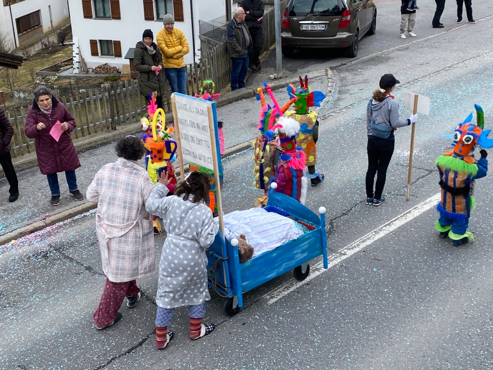 Fasnachtsgruppe mit Kinderbett am Fasnachtsumzug in Disentis.