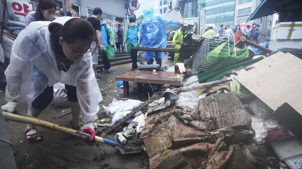 Menschen räumen nach den Überschwemmungen in Seoul auf