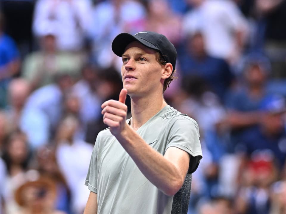 Tennisspieler gibt Daumen hoch auf dem Platz.