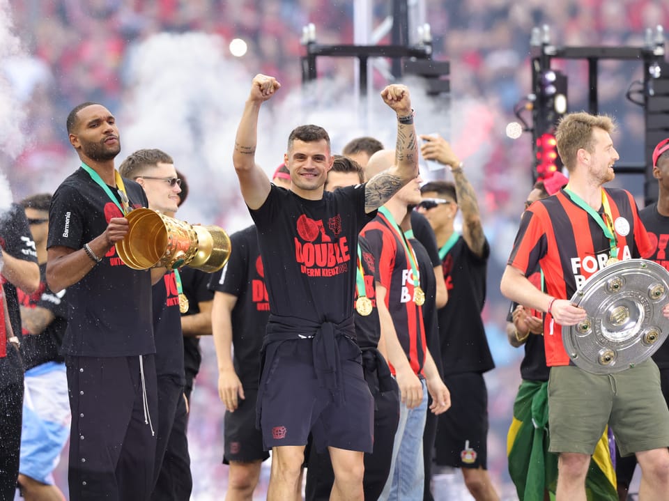 Granit Xhaka und seine Teamkollegen präsentieren die Meisterschale und den DFB-Pokal während der Meisterfeier.