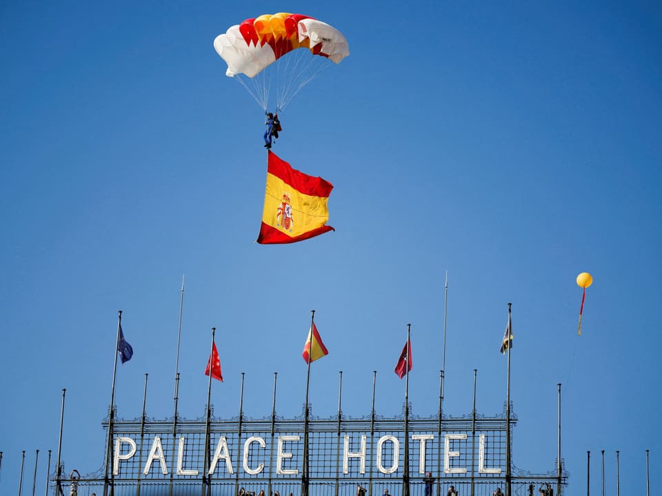 Ein Fallschirmspringer fliegt über das Palace Hotel.