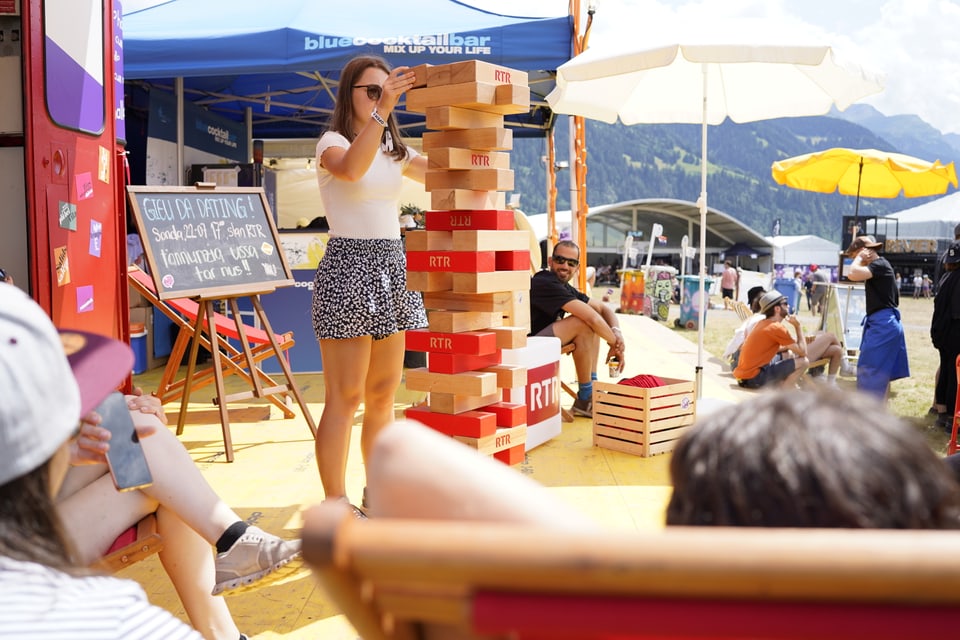 Besucherin am Riesenjenga spielen vor der RTR Gondel.