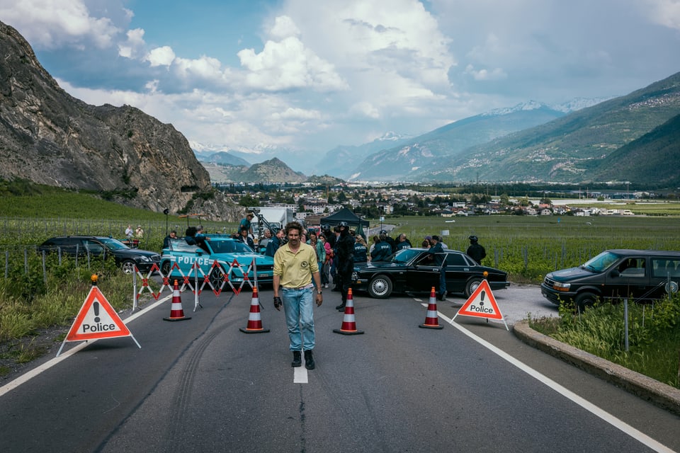 David Constantin alias Bax steht auf einer für den Dreh gesperrten Strasse. Im Hintergrund mehrere Autos. 