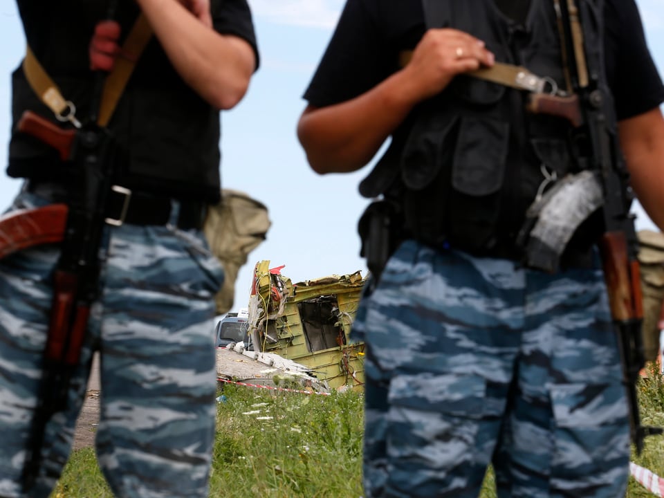 Schwerbewaffnete prorussische Rebellen überwachen das Absturzgebiet in der Ostukraine. 