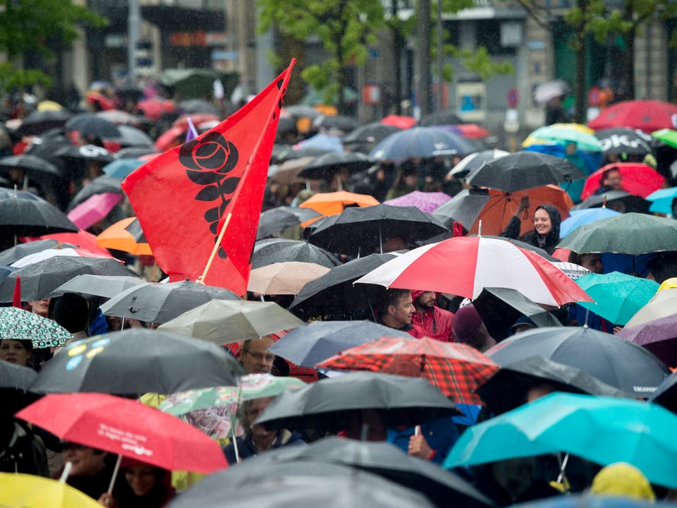 Regenschirme und eine SP-Fahne