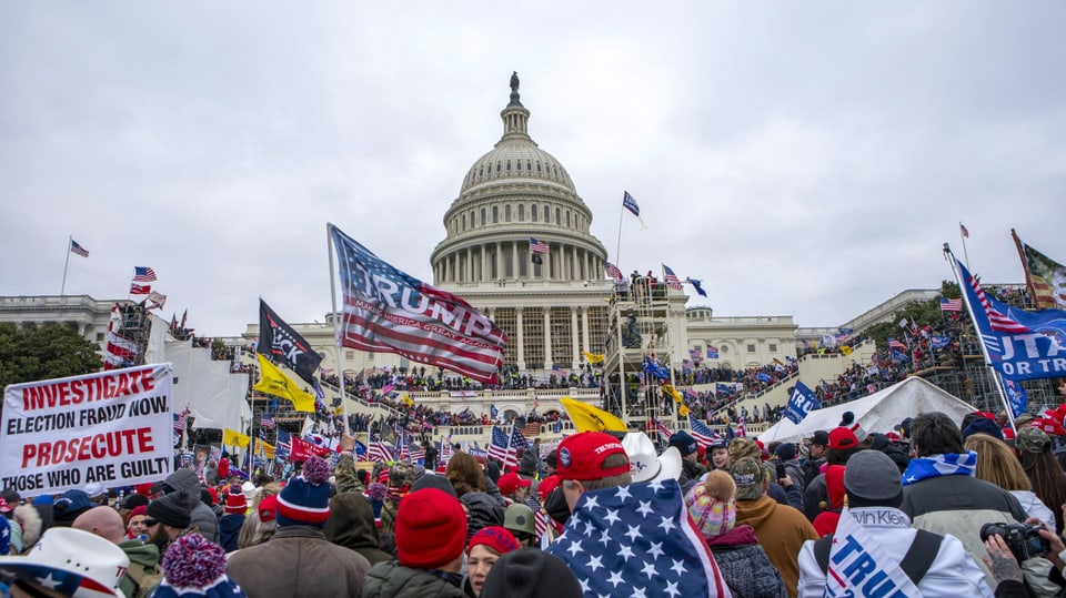 Blick aus der Menge aufs US-Kapitol; Trump-Fahnen werden geschwenkt
