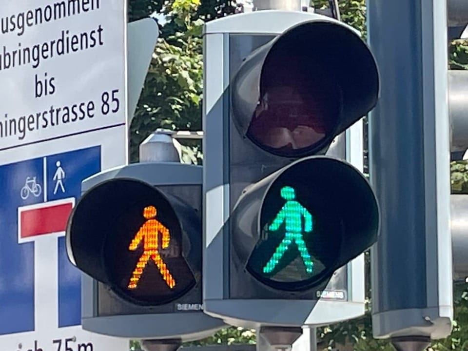 Ampel zeigt rotes und grünes Fussgängersignal.