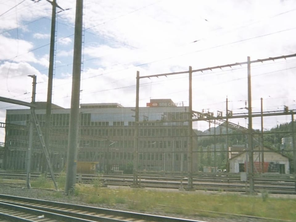 Gebäude neben Gleisen, fotografiert durch Zugfenster.