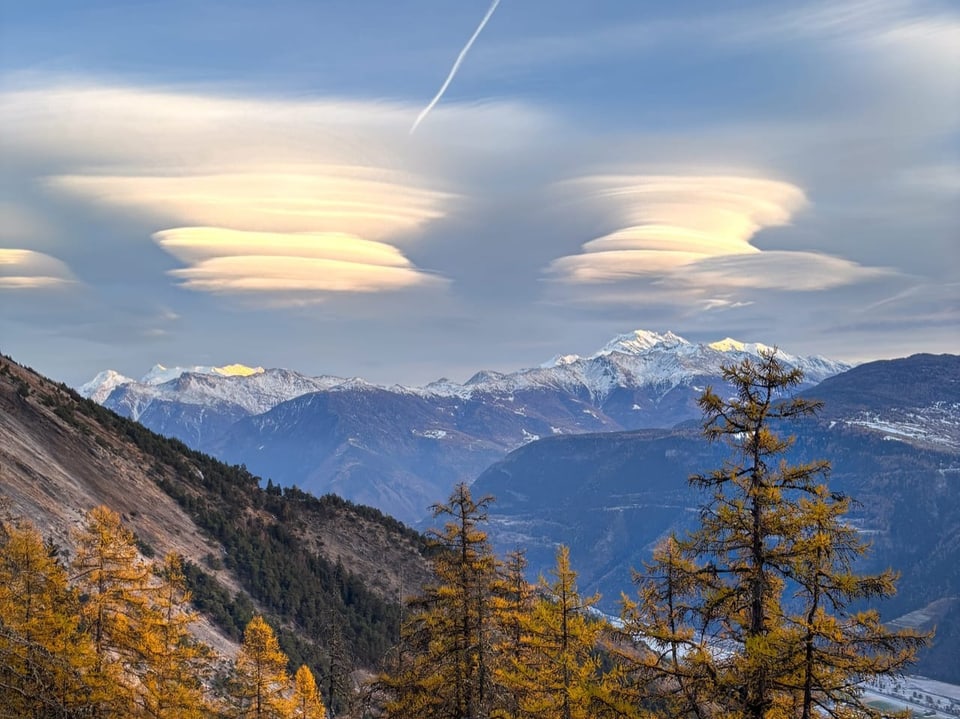 Alpenlandschaft mit lentikularen Wolken über den Bergen.