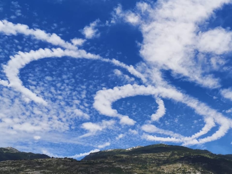 Blick auf ringförmige Wolken vor blauem Himmel.