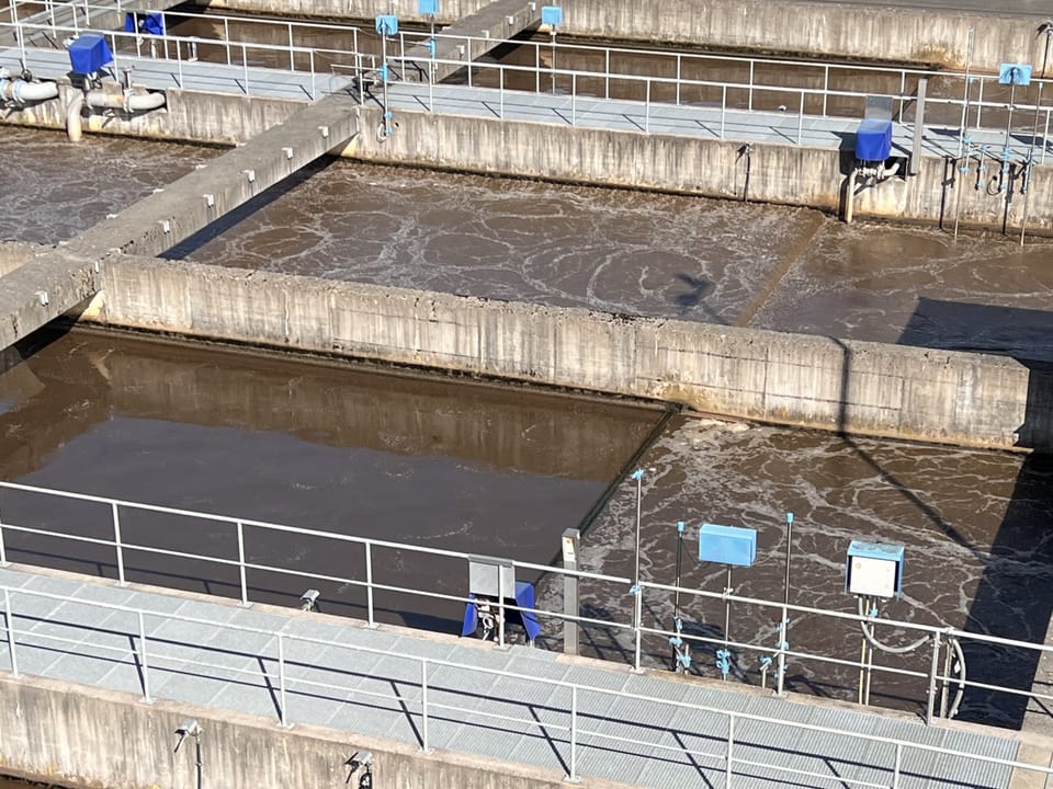 Grosse Betonbecken mit schäumendem braunem Wasser.