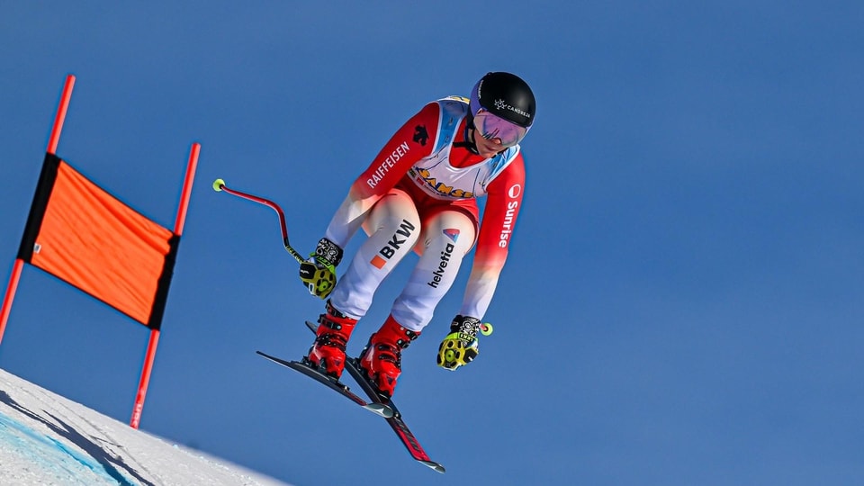 Skifahrerin bei Abfahrt auf Piste.