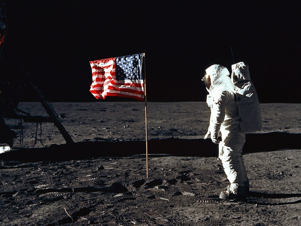 Astronaut auf dem Mond mit US-Flagge.