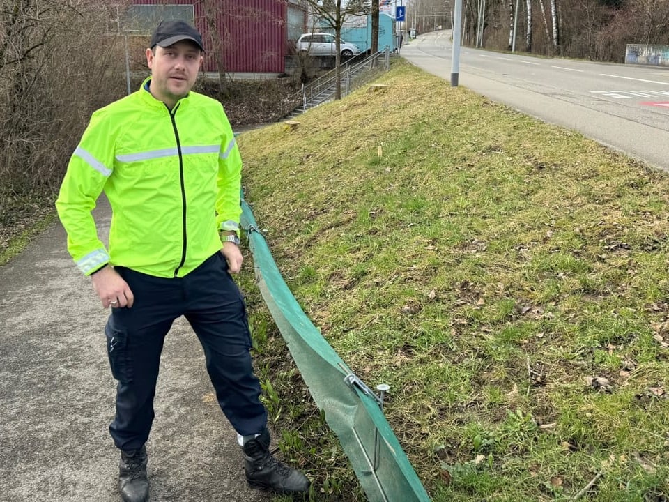 Christoph Noger steht an der grünen Leitplanke, welche die Amphibien zur Fussgängerunterführung bringen sollen.