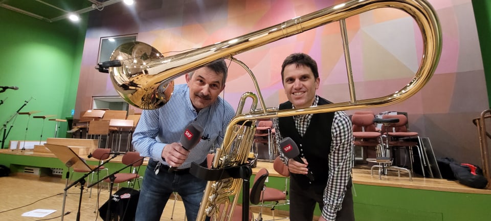 dus moderaturs guardan tras in instrument da musica, il cimbasso