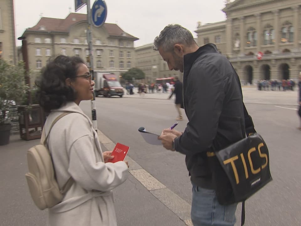 Ein Mann unterschreibt einen Unterschriftenbogen.