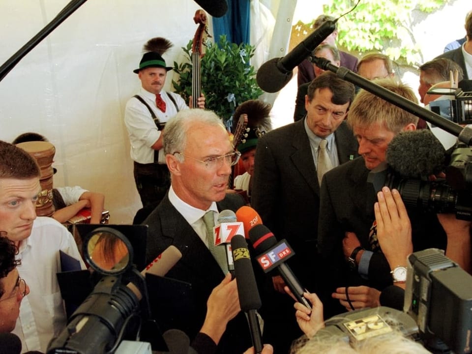 Franz Beckenbauer gibt in Zürich vor Mikrofonen und Kameras Auskunft.