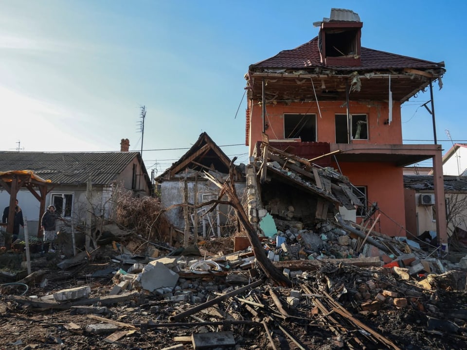 Zerstörtes Haus mit Trümmern im Vordergrund.