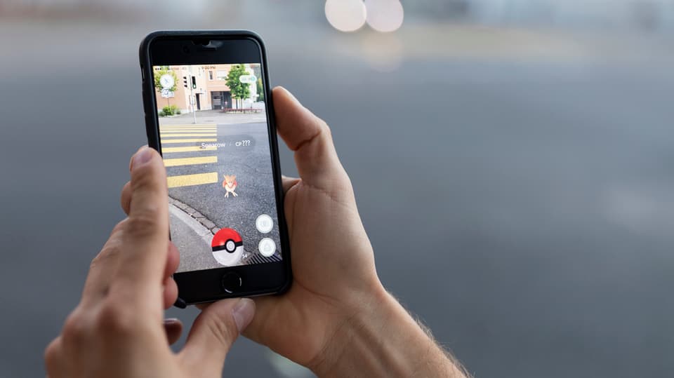 Jemand hält ein Smartphone, auf dem «Pokémon Go» gespielt wird in die Kamera.
